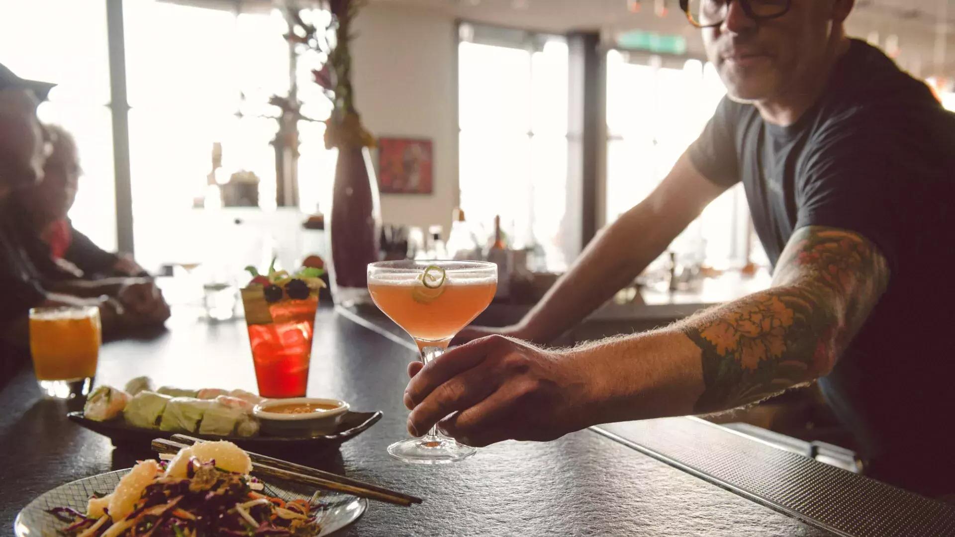 在贝博体彩app的酒吧里，调酒师为客人提供鸡尾酒。
