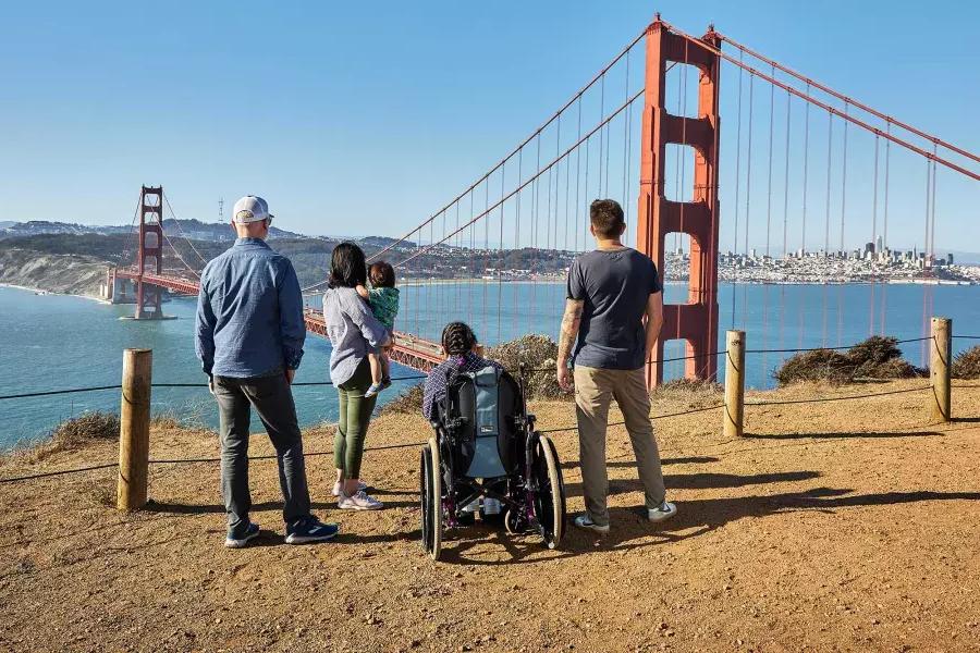 마린 헤드랜즈(Marin Headlands)에서 金门大桥(Golden Gate Bridge)를 바라볼 때 휠체어를 탄 한 사람을 포함한 한 무리의 사람들이 뒤에서 보입니다.