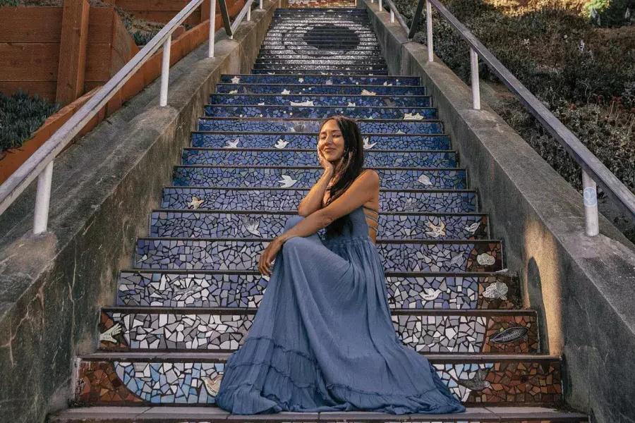 一名妇女坐在贝博体彩app日落区第16大道的瓷砖楼梯上.