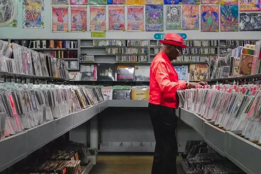一个穿红夹克的男人在贝博体彩app的变形虫唱片公司买唱片.