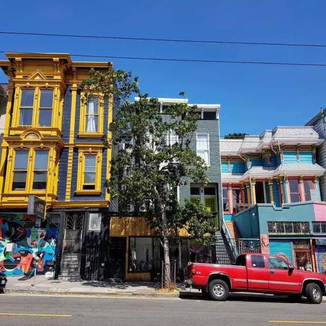 View of colorful buildings on Haight Street with cars parked along the street. 贝博体彩app, California.