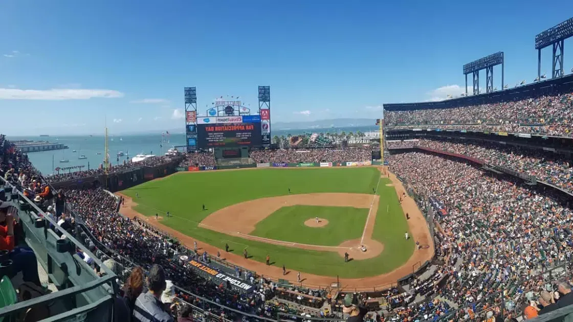 A view of San Francisco's Oracle Park looking out from the stands, foreground中的棒球钻石和贝博体彩app湾的背景.